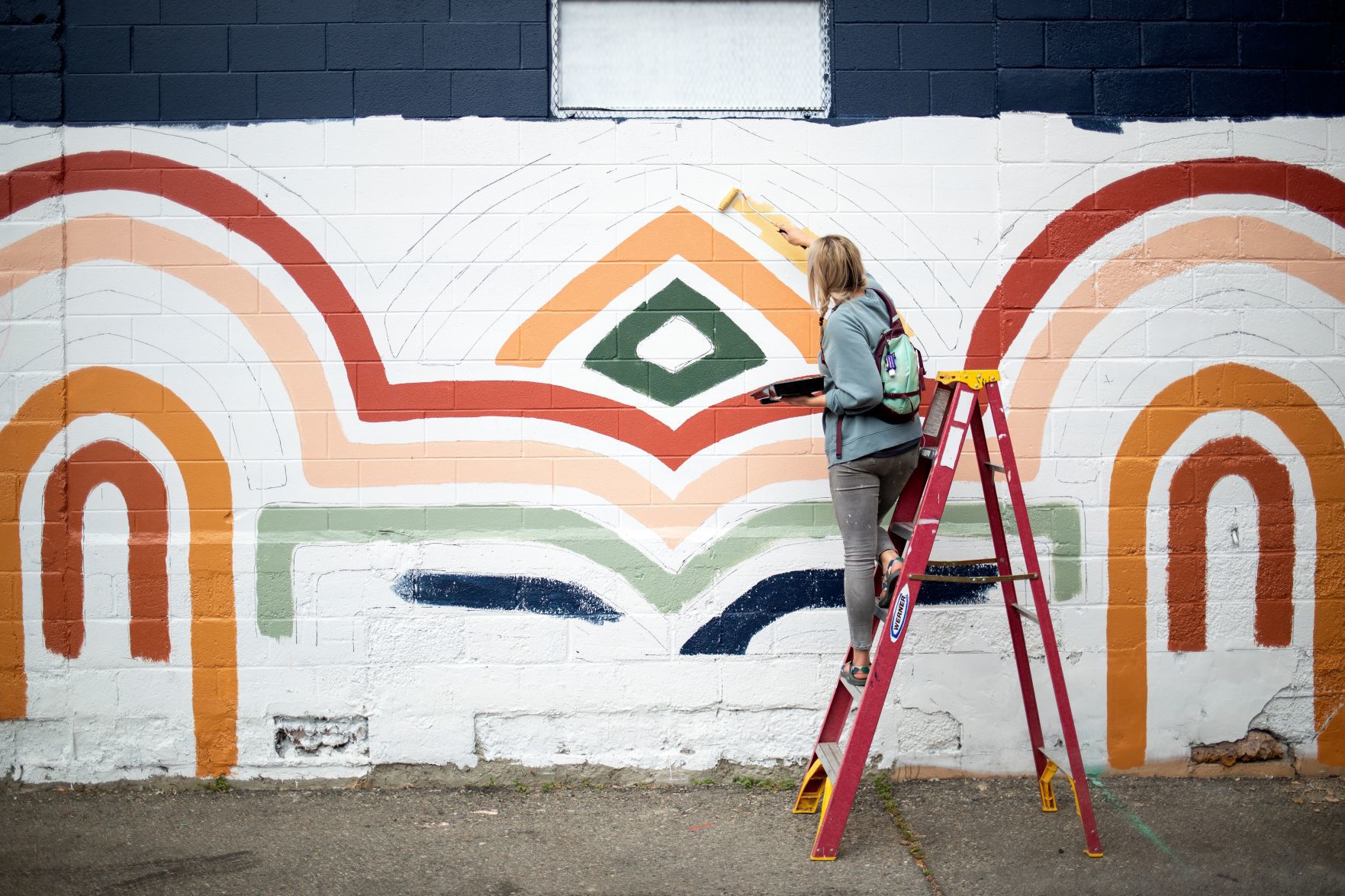 Molly Schiltz paints a mural on The Pub Station